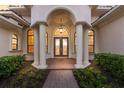 Grand front entrance with decorative glass doors, classic columns, and beautiful landscaping at 3769 Caledonia Ln, Sarasota, FL 34240