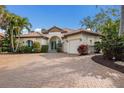 Beautiful home showcasing a paved driveway, clay tile roof, manicured landscaping, and an attached two-car garage at 4946 Brywill Cir, Sarasota, FL 34234