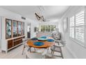 Bright dining room with round wooden table and four chairs, view into living room and kitchen at 512 W Venice Ave # 401, Venice, FL 34285