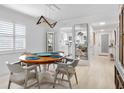 Bright dining room with round wooden table and four chairs, view into kitchen and hallway at 512 W Venice Ave # 401, Venice, FL 34285