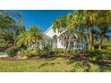 One-story house with palm trees, tropical landscaping, and a manicured lawn at 6523 Virginia Xing, University Park, FL 34201