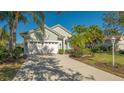Single-story house with white garage door, and tropical landscaping at 6523 Virginia Xing, University Park, FL 34201