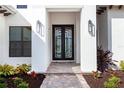 Elegant entryway with a modern black double door and brick walkway at 8367 Sea Glass Ct, Sarasota, FL 34240