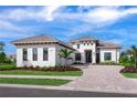 Modern two-story home with a paver driveway and tropical landscaping at 8367 Sea Glass Ct, Sarasota, FL 34240