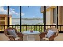 Relaxing balcony with wicker chairs and table overlooking the water at 8779 Midnight Pass Rd # 504H, Sarasota, FL 34242