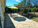 Backyard patio with pergola, seating, and a green umbrella at 1270 Manor Rd, Englewood, FL 34223