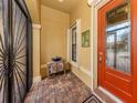 Front entry with an orange door and terracotta tile flooring at 19696 Petrino St, Venice, FL 34293