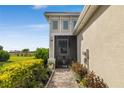 Exterior view of home showcasing a screened patio, landscaped walkway, and lush landscaping at 226 Van Gogh Cv, Bradenton, FL 34212