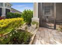 Landscaped patio with a walkway and access to a screened porch at 226 Van Gogh Cv, Bradenton, FL 34212