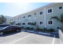 Shell Cove building exterior, featuring light teal walls and ample parking at 2310 Gulf N Dr # 205, Bradenton Beach, FL 34217