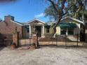 Charming yellow house with brick accents and a gated entryway at 8440 Midnight Pass Rd, Sarasota, FL 34242