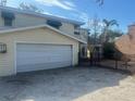 Single car garage with white door and gated backyard access at 8440 Midnight Pass Rd, Sarasota, FL 34242