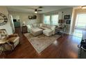 Spacious living room featuring hardwood floors, L-shaped sectional sofa, and a fireplace at 9359 Casa Grande Ave, Englewood, FL 34224