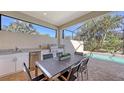 Outdoor kitchen with stainless steel appliances and dining area at 10656 Glencorse Ter, Bradenton, FL 34211