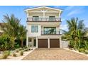 Two-story home with white exterior, brown garage doors, and a paved driveway at 112 Maple Ave, Anna Maria, FL 34216