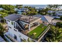 Spacious rooftop deck with artificial turf, seating, and a grill at 112 Maple Ave, Anna Maria, FL 34216