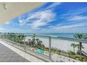 Another view of the balcony overlooking a white sand beach with palm trees, offering a serene and picturesque setting at 1800 Benjamin Franklin Dr # A405, Sarasota, FL 34236