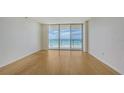 Bright living room with wood floors and sliding glass doors offering stunning ocean views and access to the balcony at 1800 Benjamin Franklin Dr # A405, Sarasota, FL 34236