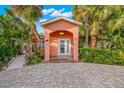 Front view of a light pink house with a double door entry and brick driveway at 235 Grant Dr, Sarasota, FL 34236