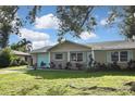 Tan house with light blue accents, a double garage door, and a large yard at 3111 Taunton W Dr, Bradenton, FL 34205