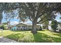 House with a large oak tree in the front yard, light blue accents, and a manicured lawn at 3111 Taunton W Dr, Bradenton, FL 34205