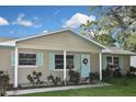 Tan house with light blue accents, a double garage door, and a well-maintained lawn at 3111 Taunton W Dr, Bradenton, FL 34205