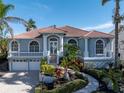 Two-story home with tile roof, columns, and a landscaped front yard at 3260 Bayou Rd, Longboat Key, FL 34228