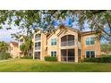 Back view of a condo building showcasing a grassy area and screened balconies at 4142 Central Sarasota Pkwy # 1428, Sarasota, FL 34238