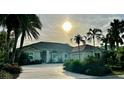 One-story house with tile roof, lush landscaping, and palm trees at 479 Summerfield Way, Venice, FL 34292