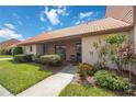 Front view of a condo with a tiled roof, landscaping, and walkway at 6542 Draw Ln # 90, Sarasota, FL 34238