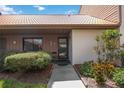 Front view of a condo with a tiled roof, landscaping, and walkway at 6542 Draw Ln # 90, Sarasota, FL 34238