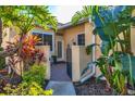 Inviting entryway with a brick walkway and tropical landscaping at 7607 Preserves Ct, Sarasota, FL 34243