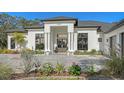 Front entrance of a modern white house with stone pillars and landscaping at 15125 Waterline Rd, Bradenton, FL 34212