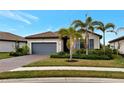 Single-story home with gray garage door and landscaping at 20861 Cattail Blvd, Venice, FL 34292