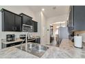 Modern kitchen with dark cabinetry, stainless steel appliances, and granite countertops at 2155 Jagust Rd, North Port, FL 34288