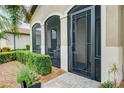 Front entrance with a screened porch and a decorative iron door at 23463 Copperleaf Dr, Venice, FL 34293