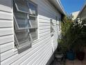 View of side of home featuring three awning windows and garden at 3710 Gulf Of Mexico Dr # D19, Longboat Key, FL 34228