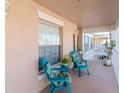 Small balcony with teal chairs and potted plants at 4207 Caddie E Dr # 202, Bradenton, FL 34203