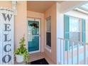 Front entrance with teal door and welcome sign at 4207 Caddie E Dr # 202, Bradenton, FL 34203