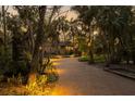 Brick driveway leading to a stunning home with landscape lighting at 5112 Jungle Plum Rd, Sarasota, FL 34242