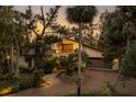Two-story home with brick driveway, lush landscaping, and palm trees at 5112 Jungle Plum Rd, Sarasota, FL 34242