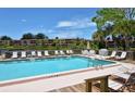 Community pool with plenty of lounge chairs for relaxation at 5369 Lake Arrowhead Trl # 17A, Sarasota, FL 34231