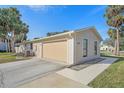 Tan house with attached garage and a walkway at 5384 Sarapointe Ct, Sarasota, FL 34232
