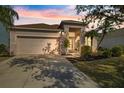 Lovely single-story house with a garage and landscaping, pictured at dusk at 6516 Rock Bridge Ln, Ellenton, FL 34222