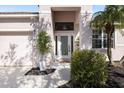 Front entry with a decorative glass door and welcoming landscaping at 6516 Rock Bridge Ln, Ellenton, FL 34222