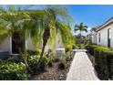 Landscaped walkway with solar lighting and lush tropical plants at 8199 Varenna Dr, Sarasota, FL 34231