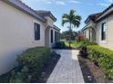 Brick walkway leading to the back of the property with lush landscaping at 8199 Varenna Dr, Sarasota, FL 34231