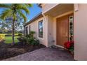 Home entrance with a brown door and decorative plants at 8224 Varenna Dr, Sarasota, FL 34231
