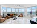 Spacious living room with bay windows, leather furniture, and marble floors at 888 Blvd Of The Arts # 1408, Sarasota, FL 34236