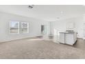 Open living room with carpeted floor, vinyl plank flooring in kitchen area, and access to backyard at 10611 Ladybug Cv, Parrish, FL 34219